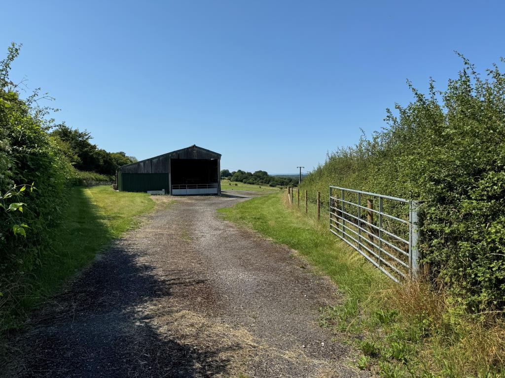 Lot: 75 - FARM BUILDINGS WITH POTENTIAL AND SIX ACRES IN A BEAUTIFUL RURAL SETTING - Looking Into the Site from the Road